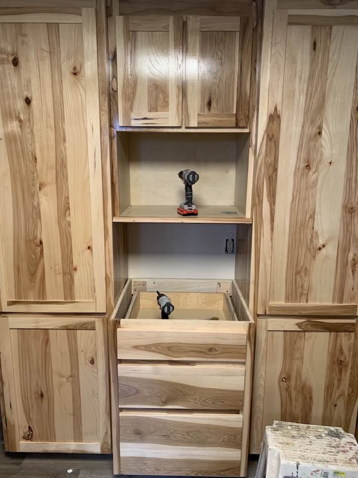 A kitchen cabinet featuring a sink, with a countertop and storage space below.