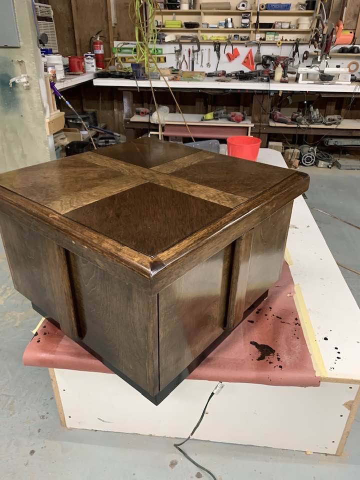 A wooden box placed on a table, showcasing its natural texture and grain.
