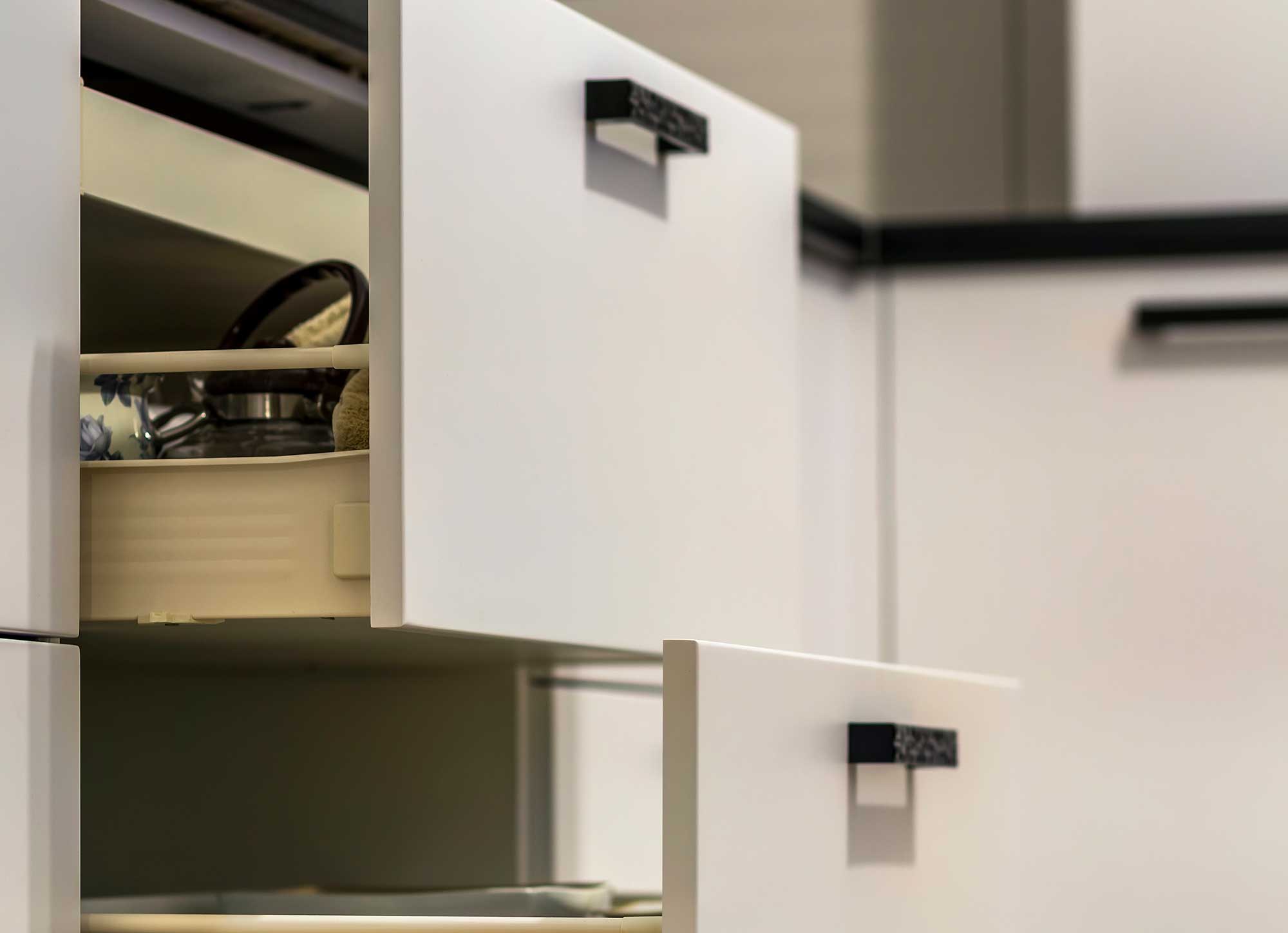 Close-up of white cabinets with pull-out drawers for functionality.